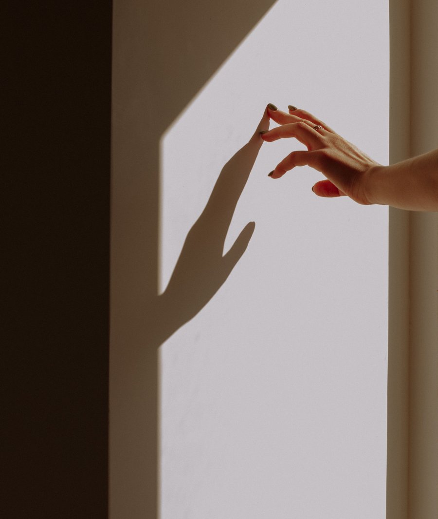 Shadow of a hand on a sunlit wall, interior atmosphere for a condo rental.